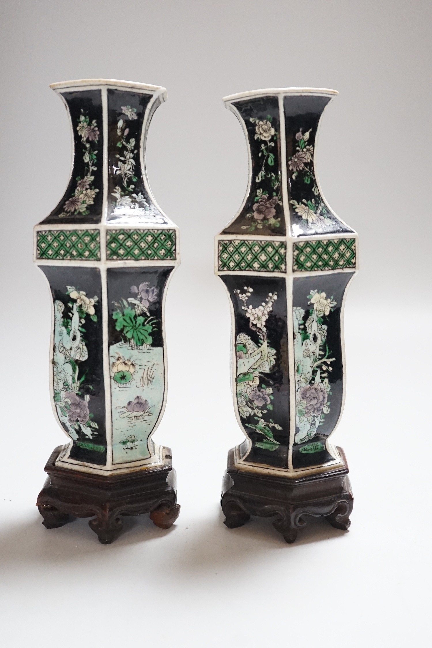 A pair of Chinese famille noire hexagonal vases, late 19th century, wood stands, 21cms high including stands